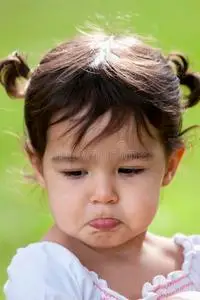 在户外撅嘴的小女孩照片