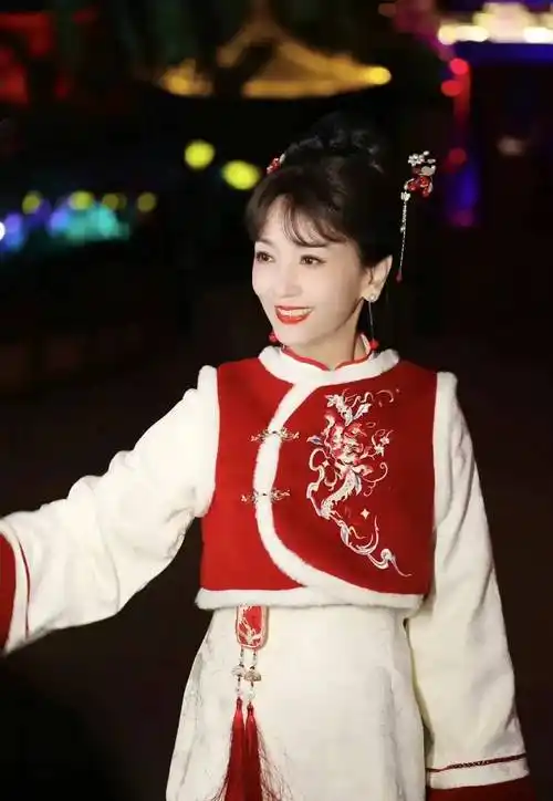 "照片中的赵雅芝,身着红色中国风马甲和白色旗袍