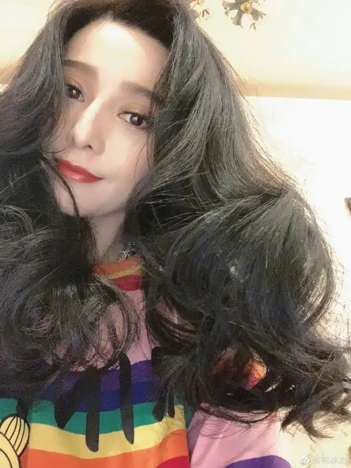 照片中,范冰冰梳大波浪卷发魅惑性感,妆容精致红唇明艳撩人.