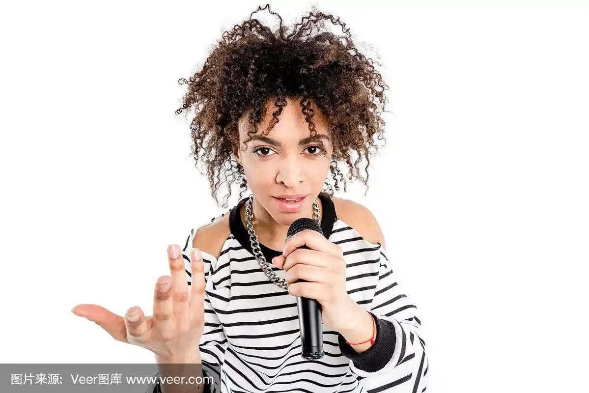 美丽的年轻重金属歌手与麦克风唱歌和手势孤立的白色