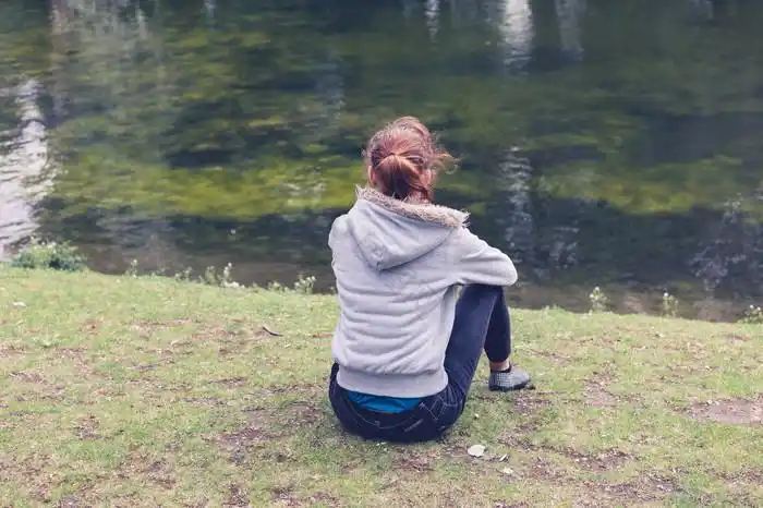 坐在草地上的女生的背影