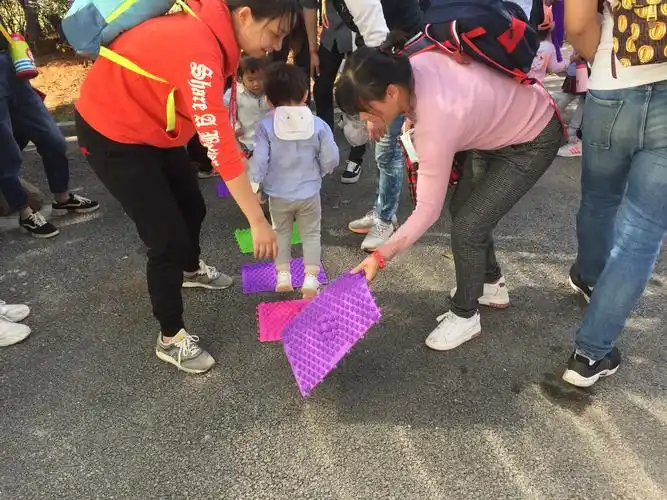 而这一关是让宝贝们一步一步踩着指压板通过,有了爸爸妈妈们的帮助