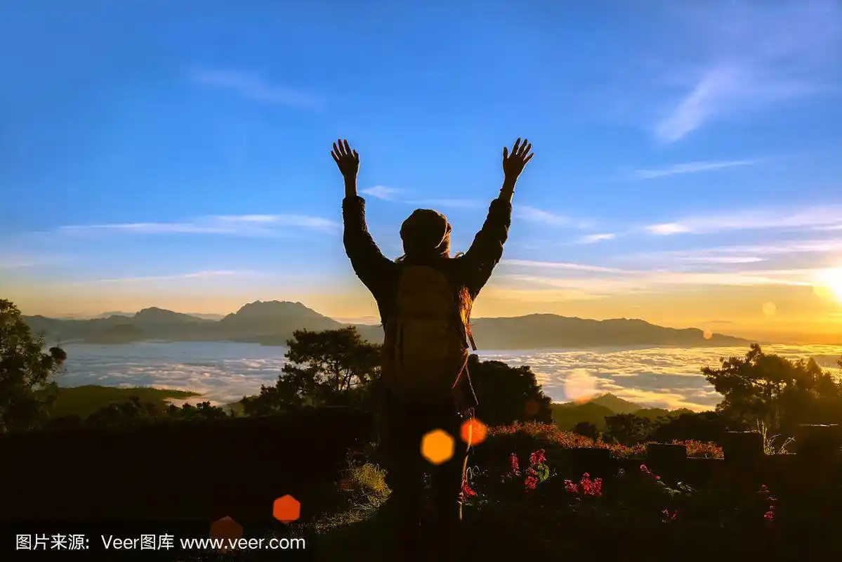 那个女孩在有美丽薄雾的山顶上看日出.旅行放松.农村自然联系.泰国