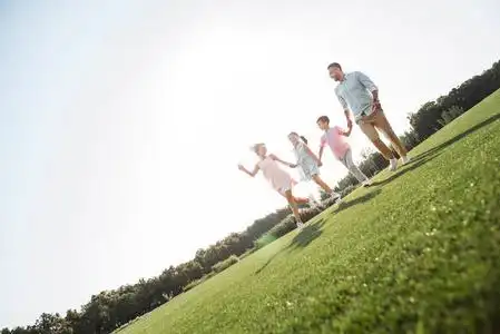 我很高兴和我的家人一家四口手牵手,面带微笑,一起在户外度过时光照片