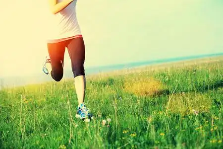 在草地上跑步的运动员照片