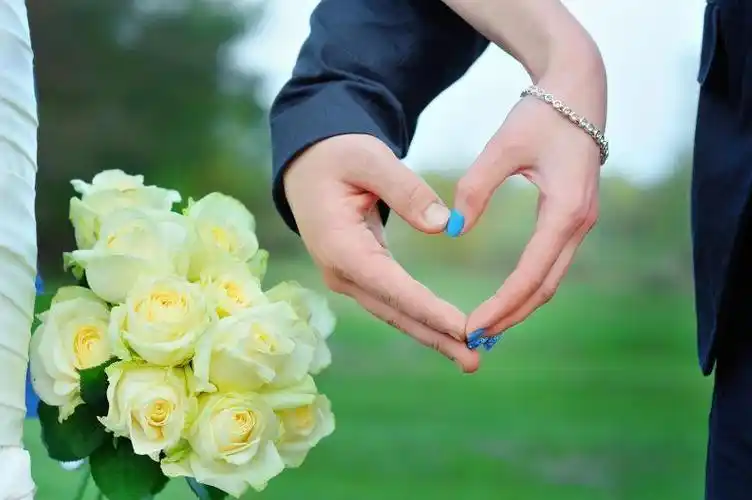 香槟酒杯上的金戒指和玫瑰花束