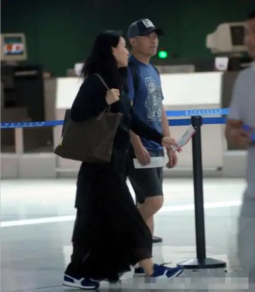 那英跟同岁老公走机场似父女一个嫩成女儿辈一个似中年老头