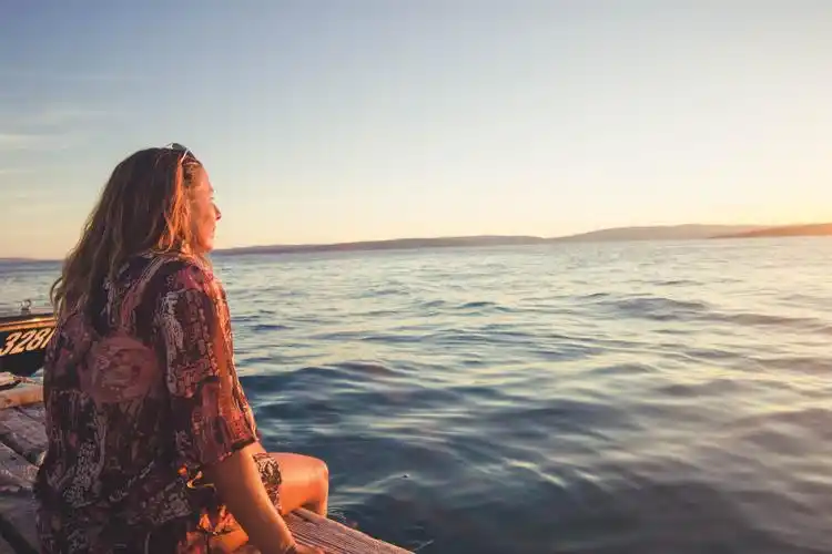坐在岸边中年女子 高清人物背景摄影图 壁纸