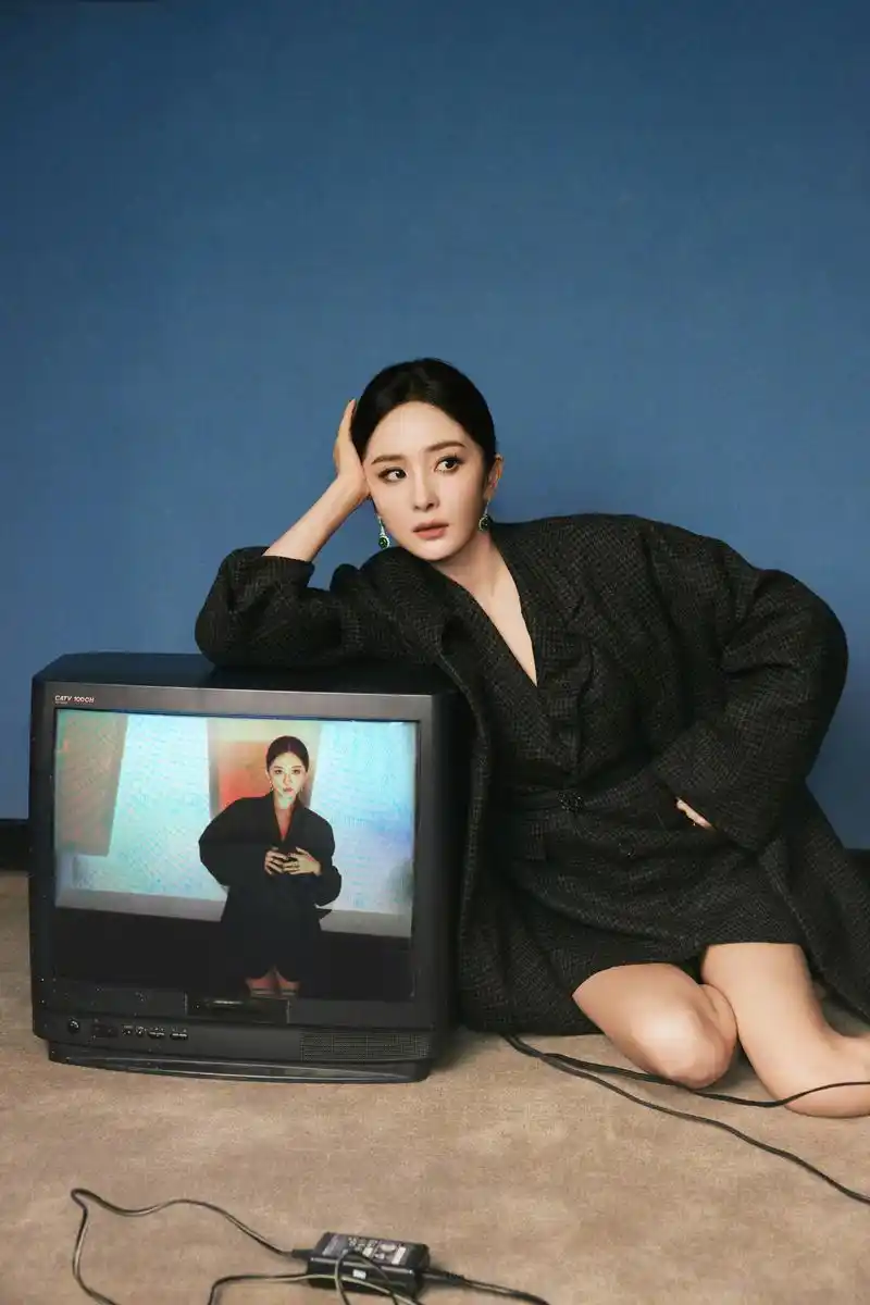 杨幂穿着黑色长外套和高跟鞋,头发向后梳,展现高冷造型的魅力!