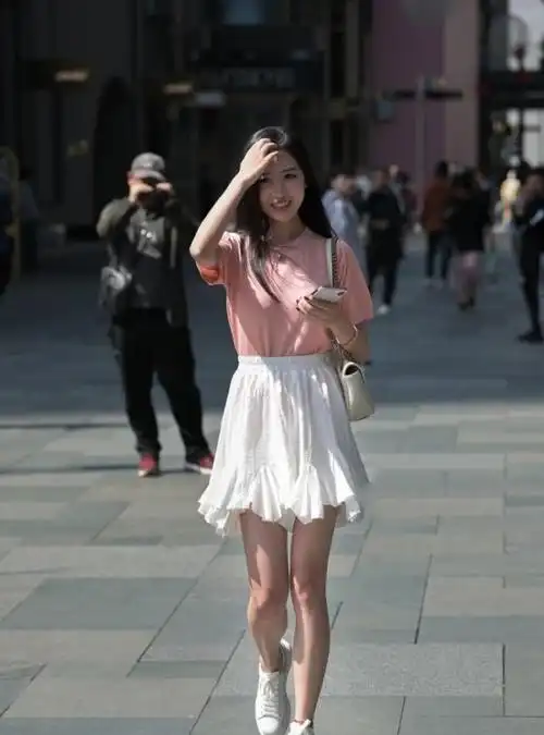 路人街拍小姐姐下身搭配白色的牛仔短裙很性感