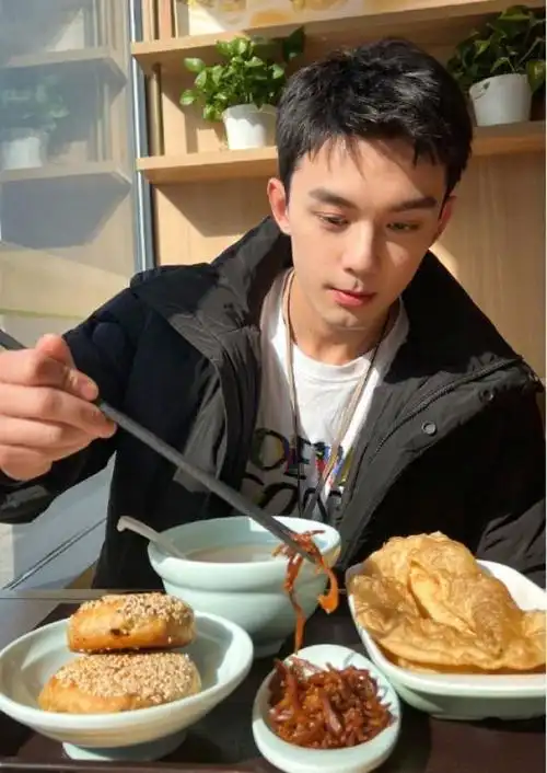 吴磊回国后吃油条,满脸笑容状态好,网友调侃:帅气真会"玩梗"