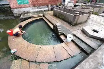 走进沙富村,沿着沙富涌往上走,可以看到一个半月形的水池,池壁一