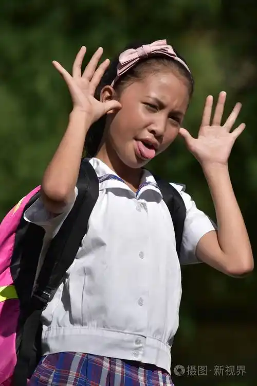 一名菲律宾女学生用书做鬼脸