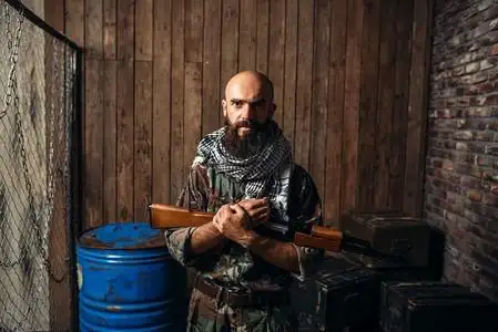 身穿制服的恐怖分子手里拿着卡拉什尼科夫步枪,男性手持武器.