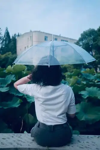伞同样低点,拍个坐着赏风景的背影,手顺势撩起不长的头发.