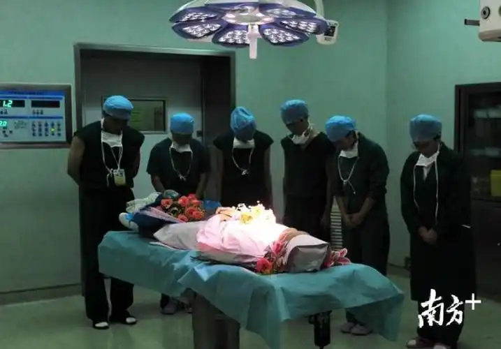 2012年,在获取器官之前医生们向捐献器官的英德少女吴华静遗体默哀.