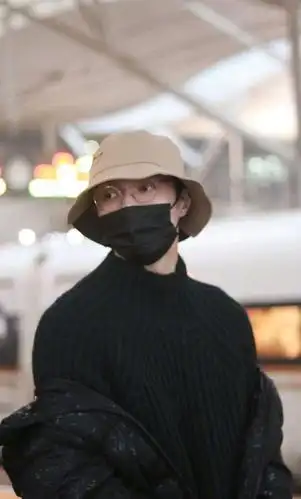 张艺兴行程饭拍图,身着深色毛衣配亮闪羽绒服,渔夫帽搭配边框眼镜