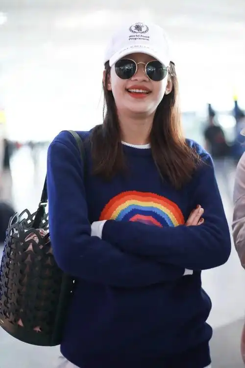 孙怡戴白色棒球帽和墨镜穿深蓝色毛衣现身机场,皮肤白皙笑容灿烂