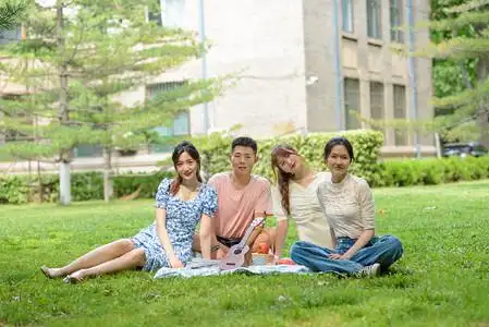 人像白天四个人草地坐着摄影图配图