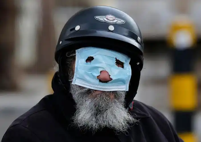 a man with a motorcycle helmet covers his face