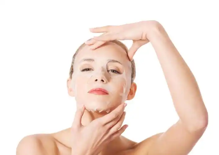 美丽的女人与胶原面膜在脸上白色衬底上面部补水