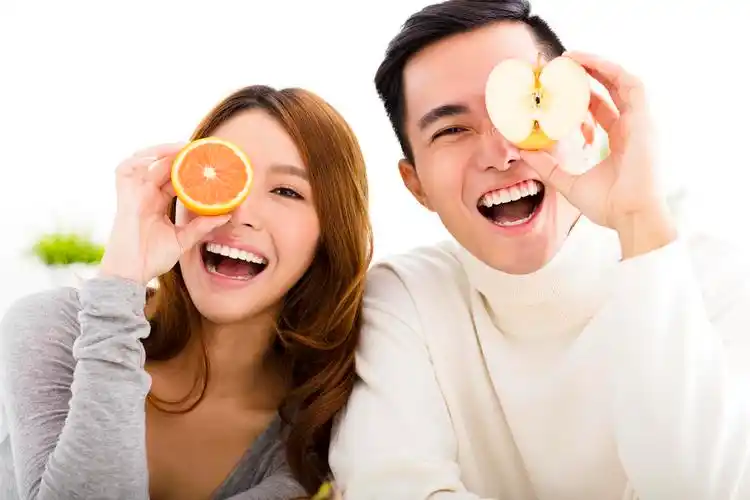 年轻夫妇拿着水果笑脸笑容