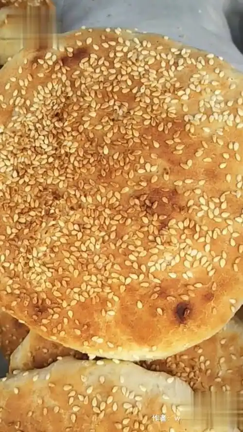 红盖烧饼发面做饼中间放上香料粉,外皮刷蜜汁撒芝麻,经铁板烤炉烤制三