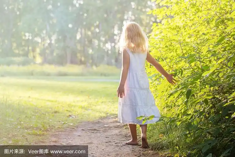 小女孩赤脚站在小路上