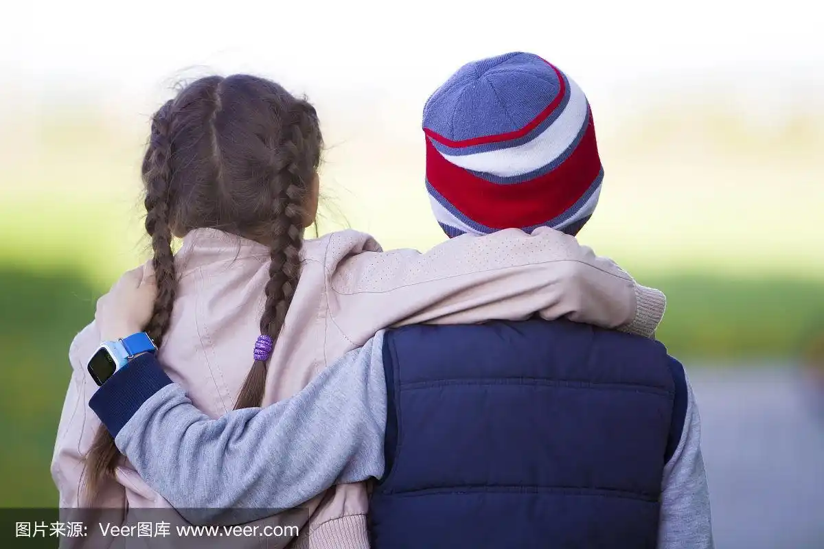 半长背影的两个孩子,女孩与长长的黑色辫子和男孩拥抱对方的肩膀上
