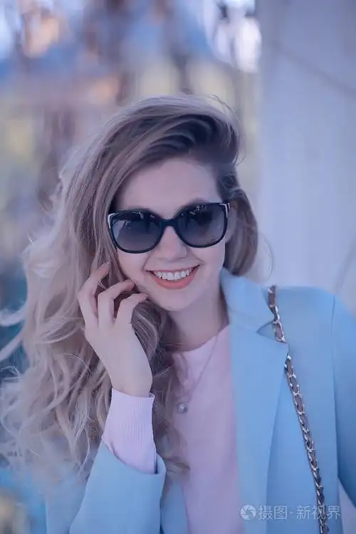 春天公园戴太阳镜的美丽年轻女子的肖像.