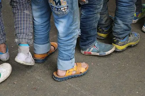 孩子们在冬天仍穿着凉鞋