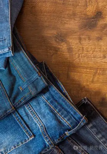蓝色牛仔裤折叠棕色木制背景上.与复制空间.顶视图
