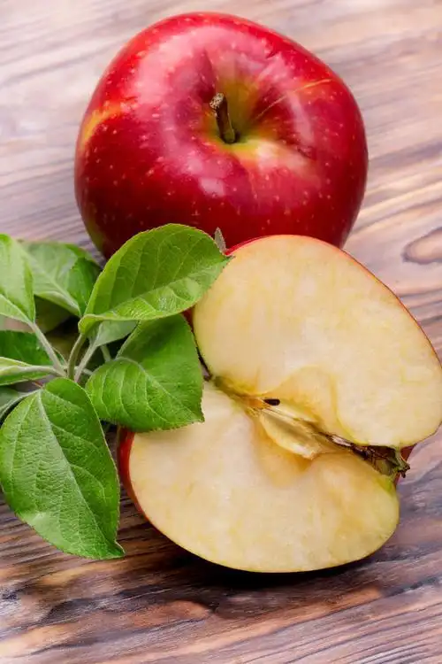 木制背景上的切开的新鲜苹果