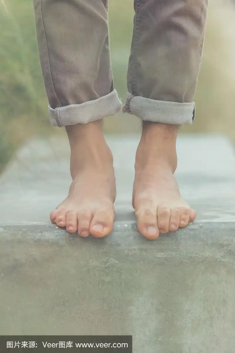 年轻英俊的男人摆着光脚的姿势