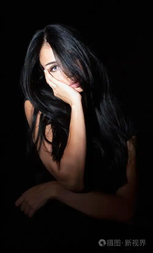 迷人的女人一头黑发在深色背景上