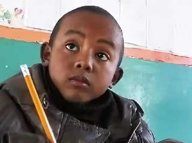 里,她坐在门口没有说话,怀里的小黑孩睁着一双晶亮晶亮的眼睛看着她