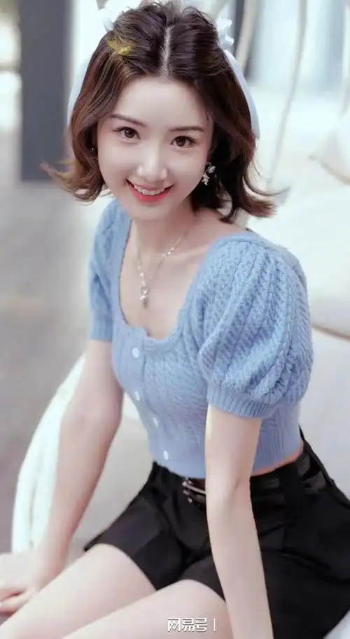 毛晓彤穿着一件短袖针织开衫,搭配一条简约的黑色休闲短裤,展现了清新