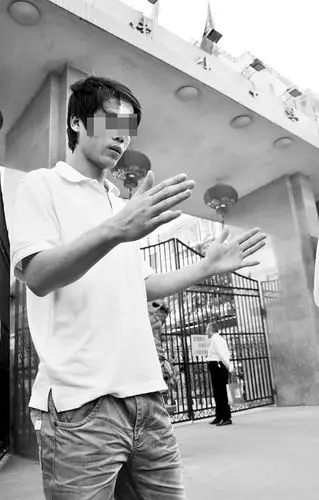 图片说明:小高比着手势对记者说:"打我的棍子有这么长"