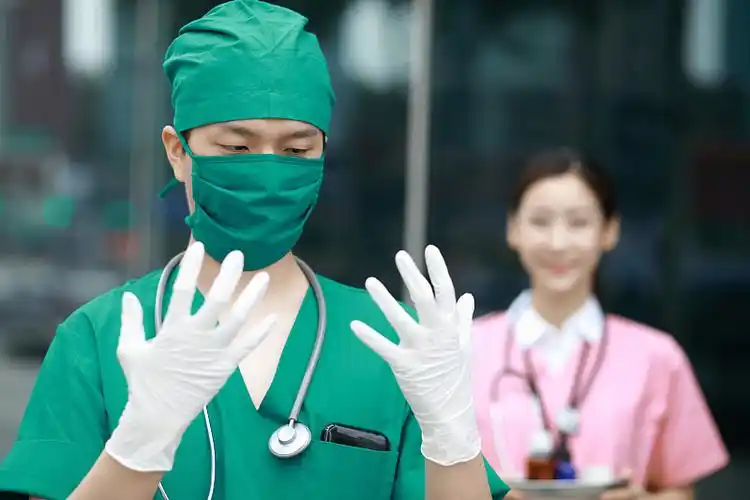 外科医生看着戴着外科手套的手图片id:vcg41n1131470720