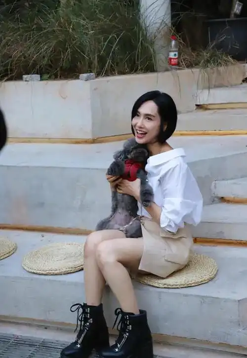 52岁朱茵近照身穿白色衬衫搭配米色短裙休闲时尚