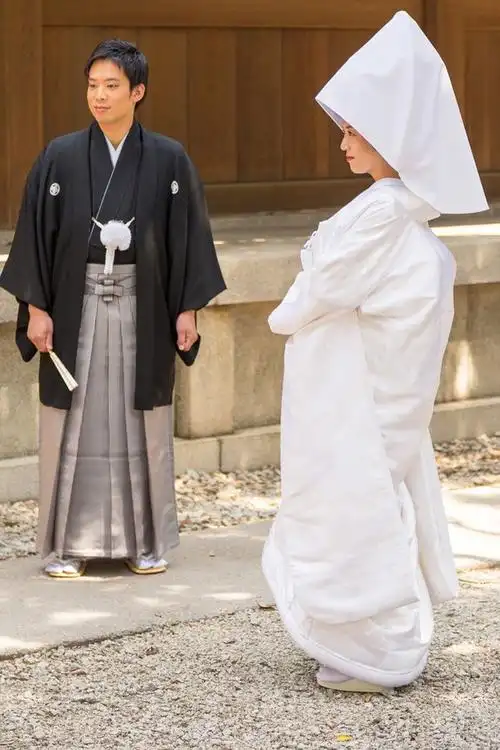 新娘穿着象征纯净无暇的"白无垢",与穿着素雅的丈夫并肩,并有穿着"黑