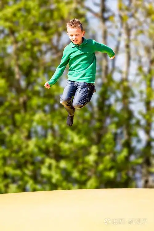 快乐的小男孩在蹦床上跳跃