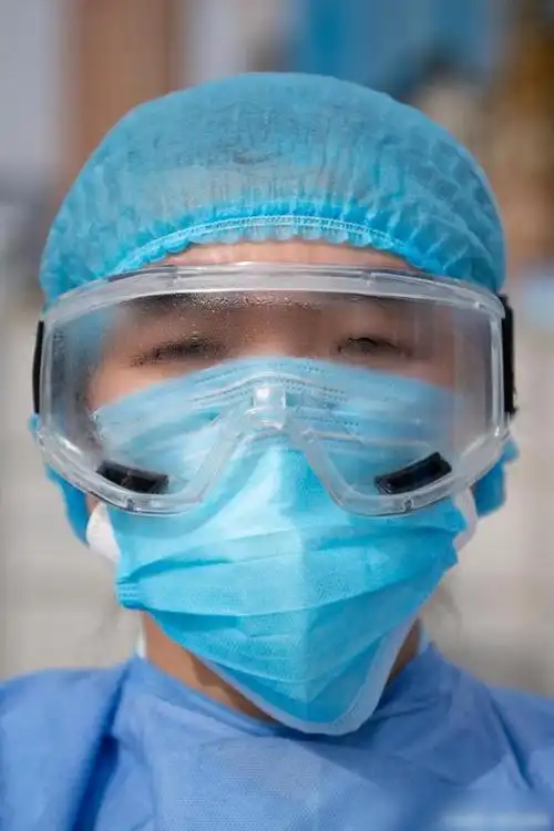 全副武装的基层医疗机构医务人员,因为长时间工作而使得护目镜里全是