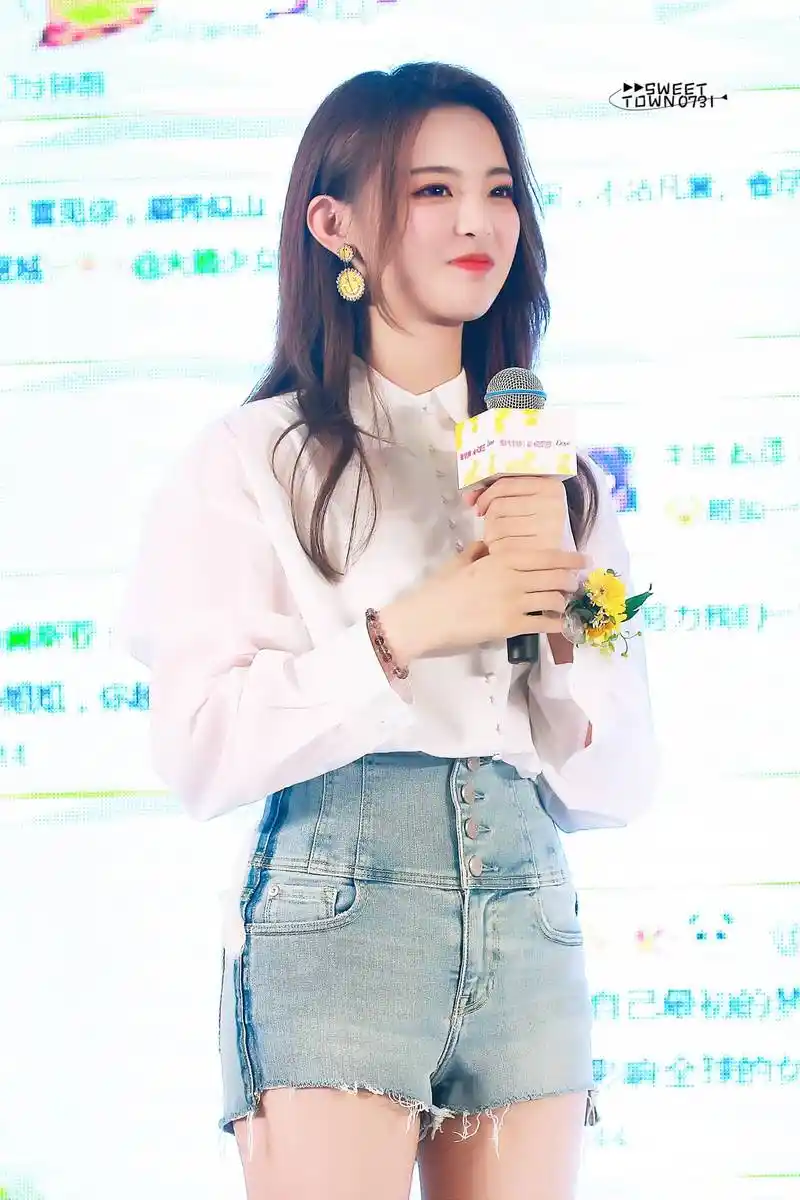 杨超越穿白衬衣搭配蓝色牛仔短裤亮相代言活动,皮肤白皙面带微笑