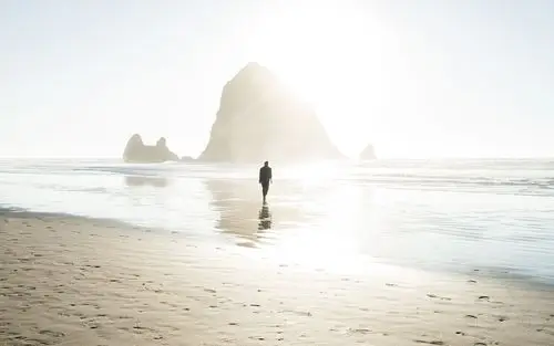 一个人在海边上漫步的图片