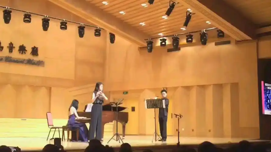 指挥家李心草老师和女儿一起演奏长笛钢琴伴奏是他的妻子,一家三口好