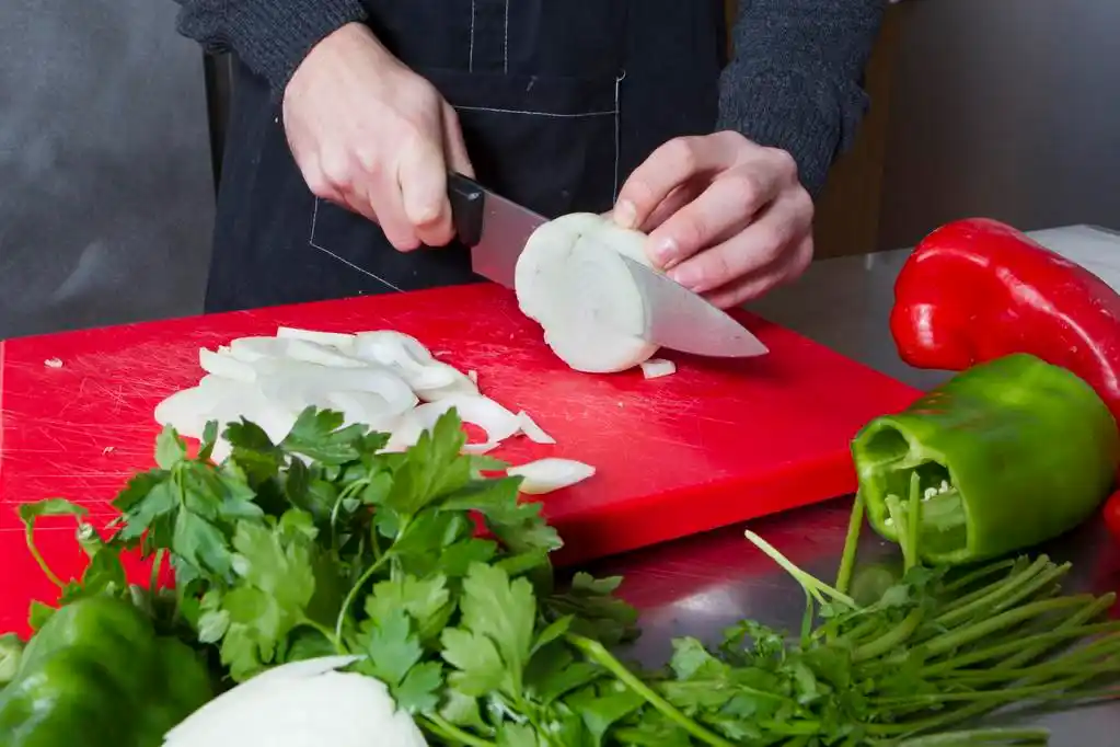 蔬菜,在厨房里的年轻厨师切蔬菜