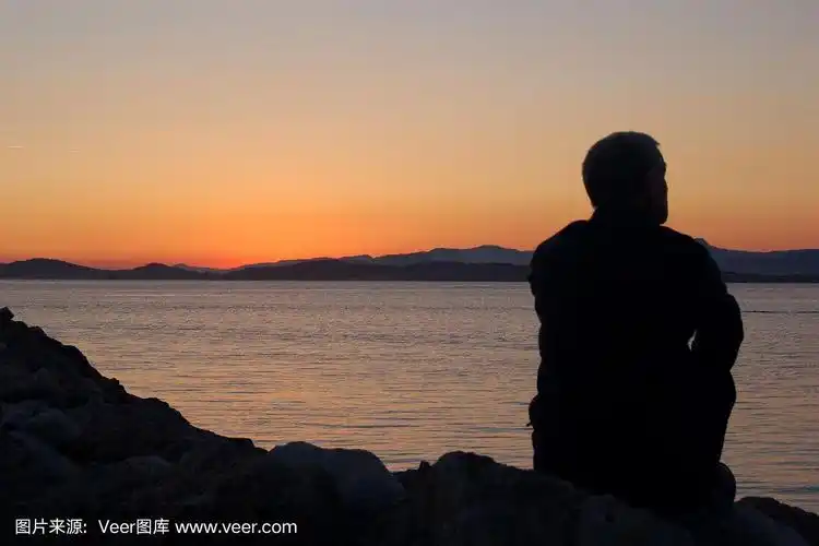 一个凝视日落的男人的剪影