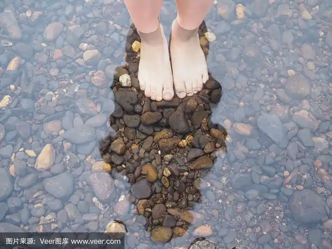 自拍光脚踩在水中的石头上,俯视图.