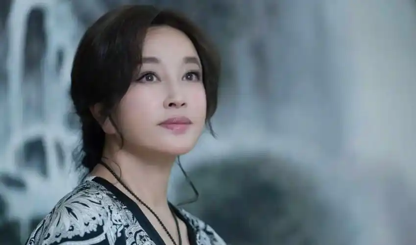 69岁刘晓庆牵男模走秀!将书法印在裙子上,穿超高厚底鞋笑容满面